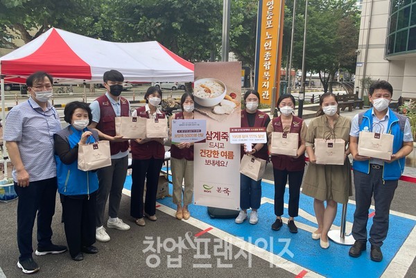 13일 보양죽 나눔 활동 진행한 본아이에프 및 복지관 직원이 기념사진을 찍고 있다.
